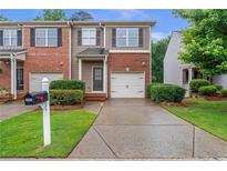 Attractive townhouse with brick and siding, well-maintained landscaping, and a private driveway at 2735 Maple Park Pl # 32, Cumming, GA 30041
