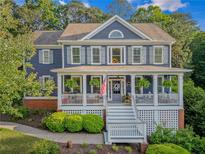Charming two-story home boasts a welcoming front porch and beautifully landscaped front yard at 321 River Green Ave, Canton, GA 30114