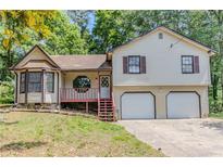Charming two-story home with a bay window, a two-car garage, and a partially wooded lot at 3120 Westwood Dr, Acworth, GA 30102