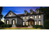 Twilight view of a beautiful home with manicured lawn and blooming flowerbeds at 2968 Ovalene Sw Ct, Marietta, GA 30064