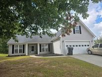 Charming home with gray siding, a two-car garage, and a well-maintained lawn and mature trees at 257 Se Ashland Park Se Ct, Lawrenceville, GA 30045