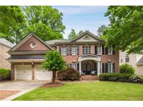 Charming two-story brick home with a two-car garage and a beautifully landscaped front yard at 3227 Collier Gate Se Ct, Smyrna, GA 30080