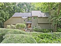 Charming two-story home with wood siding, mature landscaping, and inviting curb appeal at 4246 Loch Highland Ne Pkwy, Roswell, GA 30075