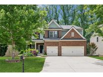 Charming brick two-story home featuring a two-car garage and a beautifully landscaped front yard at 5655 Stevehaven Ln, Cumming, GA 30028
