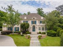 Stately home featuring blue shutters, manicured lawn, and a stone walkway leading to the entrance at 8470 Lazy Oaks Ct, Atlanta, GA 30350