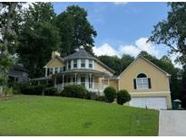 Charming two-story home with a manicured lawn, a welcoming porch, and an attached two-car garage at 1713 Dudley Dr, Woodstock, GA 30118
