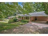 Charming brick home with covered parking, landscaped yard, and mature trees provides comfortable living at 3327 Spring Meadow Ct, Tucker, GA 30084