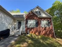 Two story home featuring a partial brick facade, complemented by well-maintained windows and shutters at 384 Daniel Mill Xing, Villa Rica, GA 30180