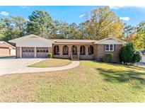 Charming brick home with a spacious front yard, two car garage, and inviting arched porch at 6418 Briarwood Ct, Riverdale, GA 30296