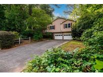Charming two-story home with a two car garage nestled among lush trees and foliage at 4324 Japonica Sw Ct, Lilburn, GA 30047