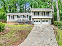 Charming home featuring a two-car garage, wood siding, and a cozy front porch, nestled among mature trees at 604 Continental Dr, Lawrenceville, GA 30044