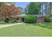 Charming brick home with a well-maintained lawn and mature trees at 148 Hurt Road Sw, Smyrna, GA 30082