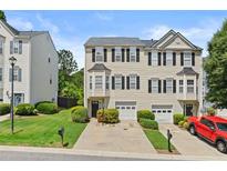 Charming townhome featuring a well-manicured lawn, one-car garage, and traditional design at 1608 Indian Way, Cumming, GA 30040