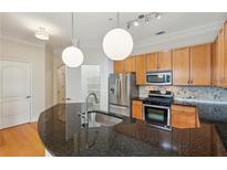 Updated kitchen features stainless steel appliances, granite countertops, and pendant lighting at 3621 Vinings Slope Se # 3510, Atlanta, GA 30339