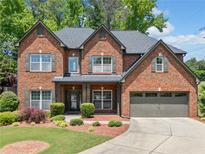 Beautiful brick home featuring a well-manicured lawn and a two-car garage at 5285 Winflow Way, Suwanee, GA 30024