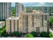 A mid-rise condominium building featuring a tan facade, balconies, and surrounding greenery in a vibrant urban setting at 1101 Juniper Ne St # 632, Atlanta, GA 30309