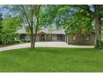 Ranch-style home with beautiful landscaping, mature trees, and a long driveway at 2055 Cactus Ln, Cumming, GA 30040