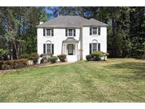 Charming two-story white brick home featuring black shutters and well-manicured landscaping at 2745 Saxon Drive, Duluth, GA 30096