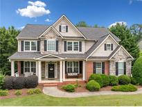 Charming two-story home featuring a stone facade, dark shutters, and a well-manicured lawn at 4715 Northridge Dr, Cumming, GA 30040