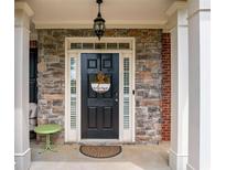 Charming front door with stone accents, welcome wreath, and overhead lighting at 4715 Northridge Dr, Cumming, GA 30040
