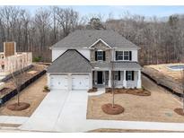New two-story home boasts a symmetrical facade, attached two-car garage, and a well-manicured lawn at 7169 Linden Dr, South Fulton, GA 30349