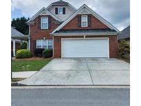Charming brick home with a well-maintained lawn, two-car garage, and inviting curb appeal at 1885 Hickory Station Cir, Snellville, GA 30078