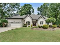 Charming single-story home featuring manicured landscaping, a two-car garage and a well-maintained lawn at 1285 Rivershyre Pkwy, Lawrenceville, GA 30043
