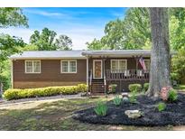 Charming single-story home featuring a welcoming front porch and nicely landscaped front yard at 6863 Recreation Ln, Acworth, GA 30102