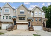 Charming townhomes featuring a brick facade, individual garages, and inviting front entrances at 4173 Chatham Ridge Dr, Buford, GA 30518