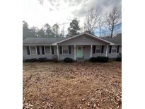 Charming ranch-style home featuring gray siding, black shutters, and a well-manicured front yard at 6540 Old White Mill Road Rd, Fairburn, GA 30213