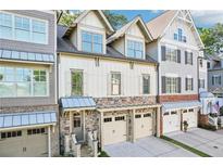 Charming townhome with stone accents, two-car garage, and a welcoming entrance at 238 Trecastle Sq, Canton, GA 30114