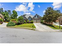 Charming single Gathering home featuring a 2-car garage, landscaped yard, and beautiful lawn at 4251 Lantern Hill Dr, Dacula, GA 30019