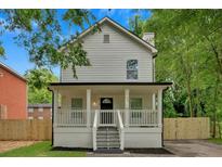 Charming two-story home with a inviting front porch, black trim, and fresh landscaping at 786 Neal Nw St, Atlanta, GA 30318