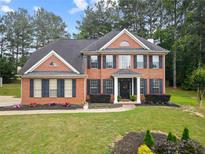 Charming two-story brick home with lush lawn and manicured landscaping at 9307 Glenleigh Way, Jonesboro, GA 30236