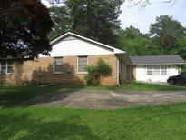Cozy brick home with a well-maintained lawn and a concrete driveway leading to the side of the house at 2447 Omaha Sw Rd, Atlanta, GA 30331