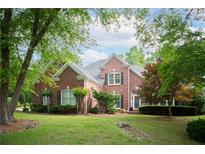Charming brick home with lush landscaping, mature trees and a well-manicured lawn at 4645 Waterford Dr, Suwanee, GA 30024