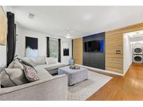 Modern living room featuring a large sectional sofa, flat-screen TV, and decorative wood paneling at 1357 Railroad Ave, Sugar Hill, GA 30518
