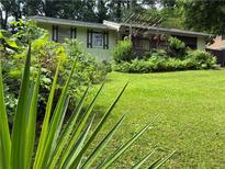 Charming home with well-manicured lawn, inviting deck, and lovely landscaping offering great curb appeal at 3291 Shady Oak Dr, Atlanta, GA 30340