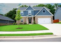 Beautiful new construction home with blue siding, stone accents, and a well-manicured lawn at 3855 Saddle Bag Ct, Dacula, GA 30019