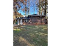 Charming brick home featuring a well-maintained lawn and mature trees providing shade at 4510 Burks Rd, Forest Park, GA 30297