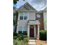 Charming two-story townhouse featuring brick accents, vinyl siding, and well-maintained front yard landscaping at 801 Old Peachtree Nw Rd # 39, Lawrenceville, GA 30024