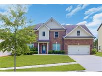 Charming two-story brick home featuring a well-manicured lawn, attached garage, and welcoming entrance at 1433 Sand Way, Lawrenceville, GA 30045