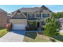 Charming two-story brick home featuring an attached two-car garage and manicured landscaping in a Gathering-friendly neighborhood at 3259 Ivy Crossing Dr, Buford, GA 30519