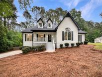 Charming two-story home boasts a modern design with black and white accents, lush landscaping, and a welcoming entrance at 339 Warrenton Dr, Douglasville, GA 30134