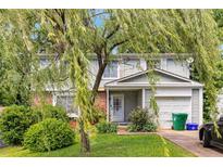 Charming two-story home with a well-maintained lawn, mature tree, attached garage, and lovely curb appeal at 4256 Village Square Ln, Stone Mountain, GA 30083