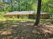 Classic brick home nestled on a treed lot offering a peaceful and private setting at 225 Oglesby Bridge Rd Se, Conyers, GA 30094
