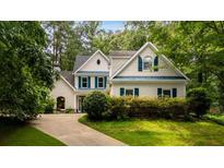 Charming two-story home featuring blue shutters, white siding, and a lush landscaped front yard at 2709 Windrush Dr, Buford, GA 30518