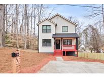 Charming two-story home with a painted brick facade and a cozy front porch, surrounded by natural landscaping at 4041 Blanton Sw Ave, Atlanta, GA 30331