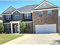 Charming two-story brick home with a well-manicured lawn, two-car garage, and inviting entrance at 5030 Mundy Dr, Cumming, GA 30028
