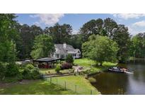 Charming home with lake access, featuring a spacious lawn, covered patio, and a private dock for waterfront enjoyment at 625 W Lake Dr, Oxford, GA 30054